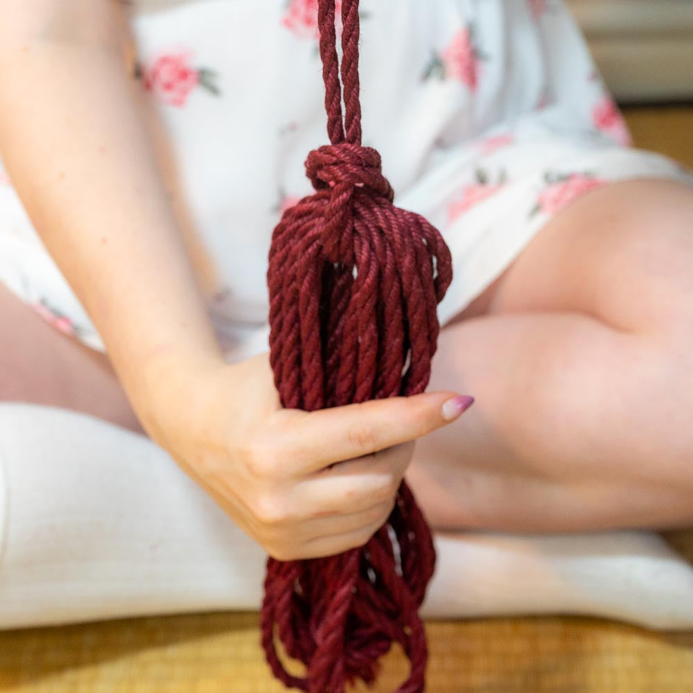 Person preparing rope by coiling and knotting it neatly