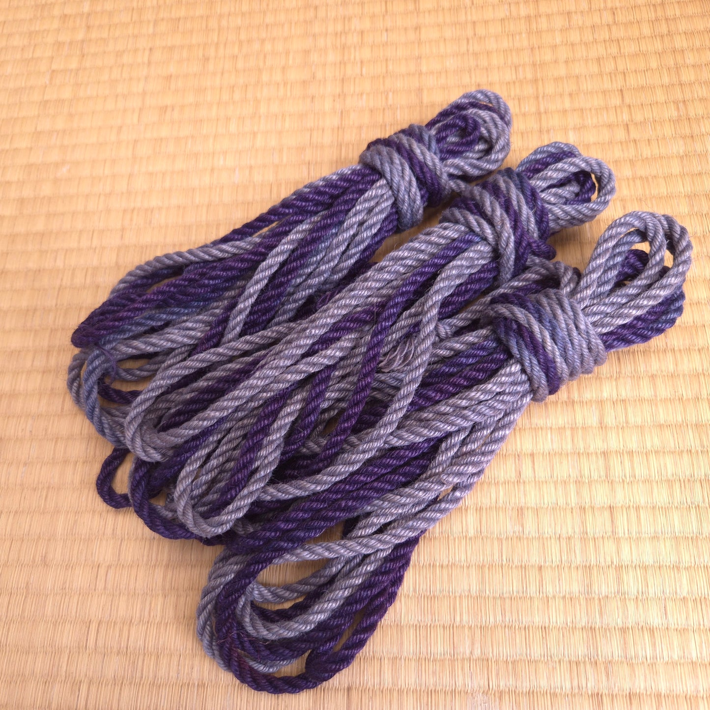 Bundle of purple and gray Shibari Rope on a  tatami surface