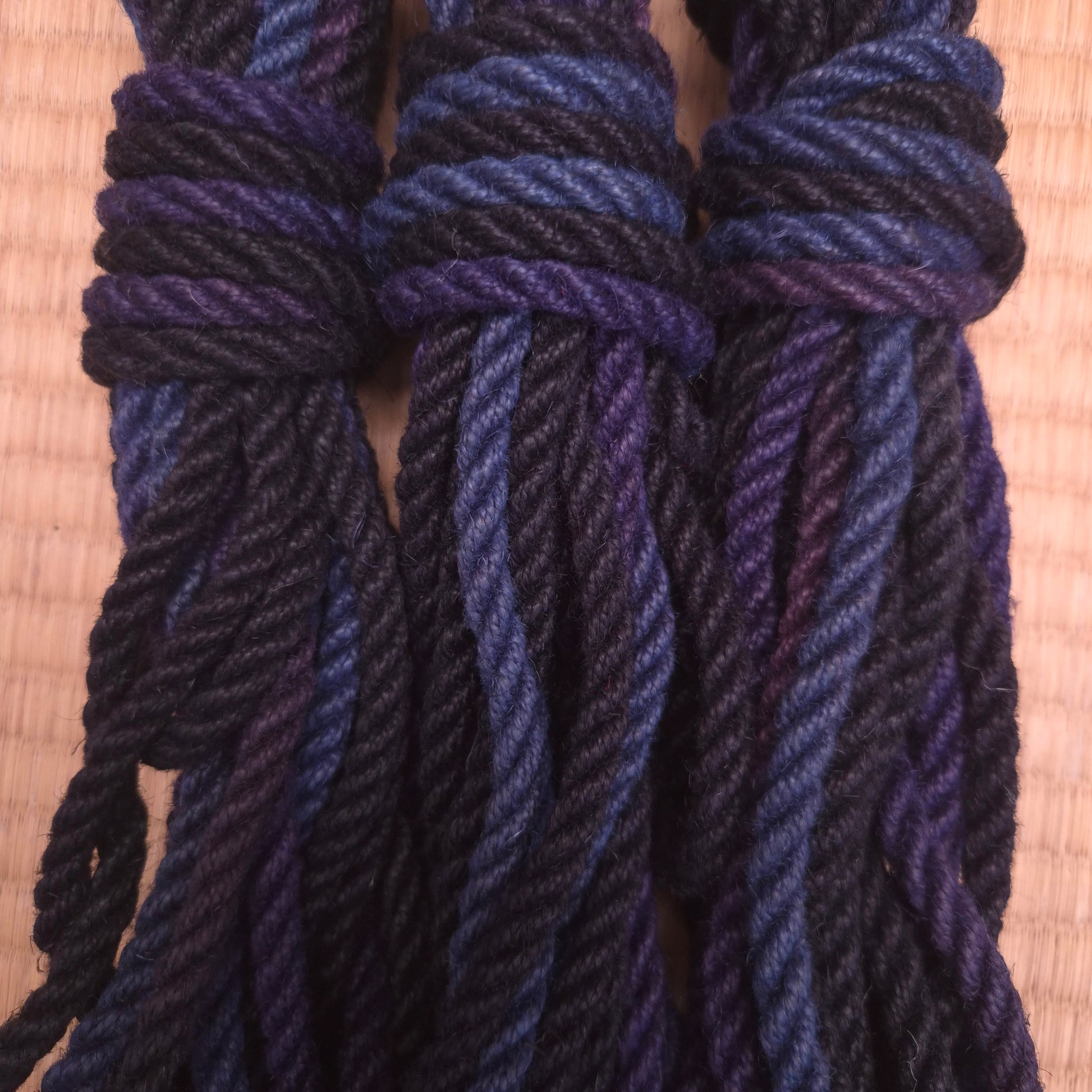 Close-up of blue and black twisted shibari rope on a tatami mat