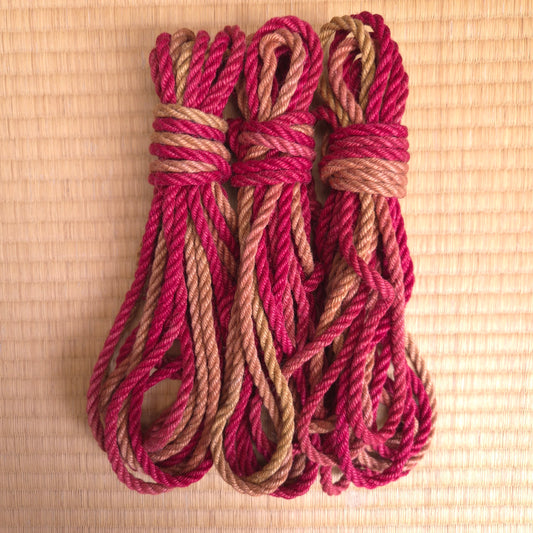 Three coils of red and brown rope on a tatami mat