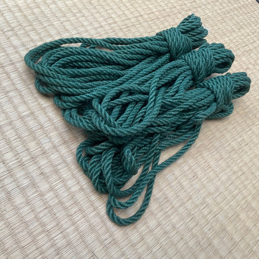 Three teal twisted rope hanked sitting on a tatami mat..