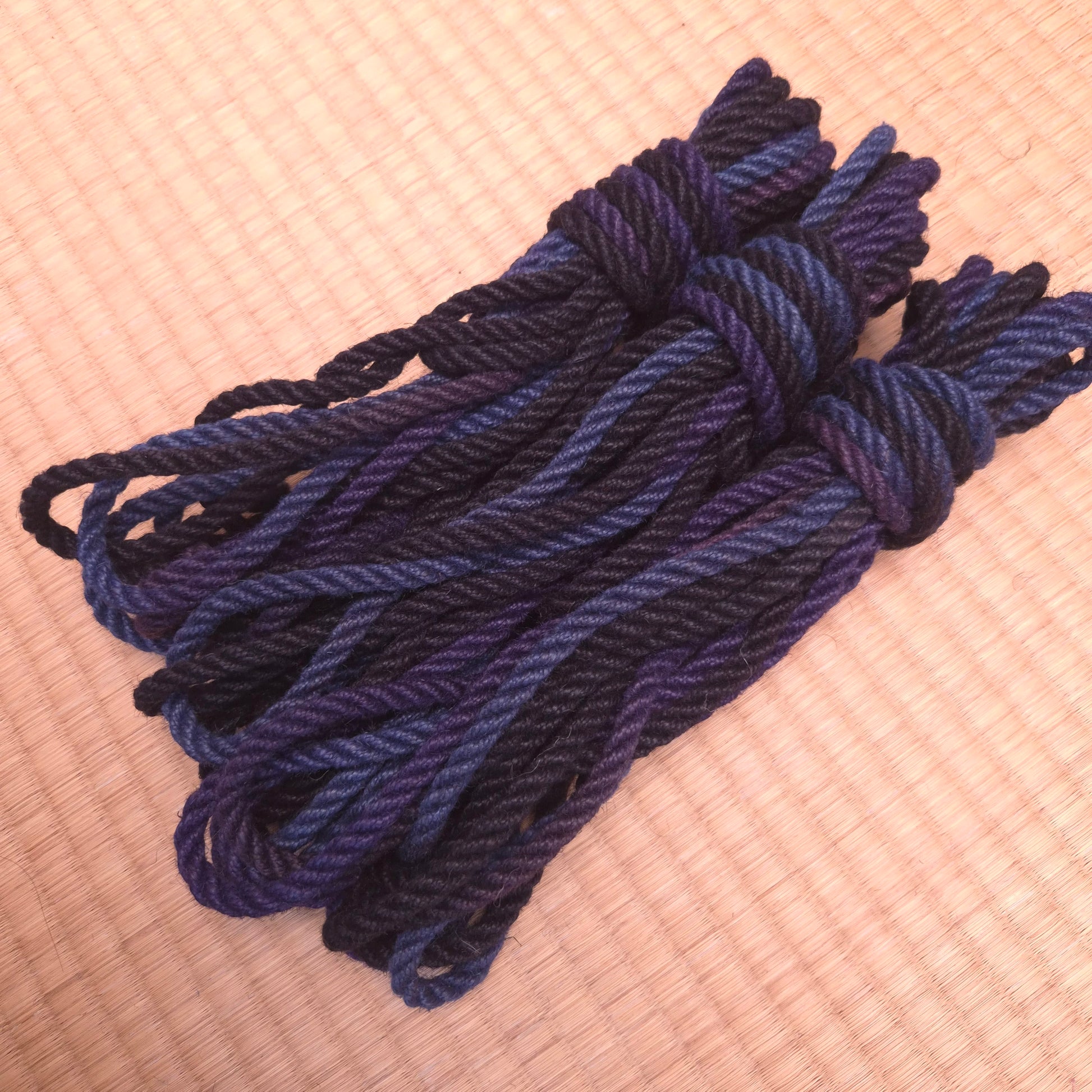 Blue Black rope bundled in a knot on a tatami Floor angled side view