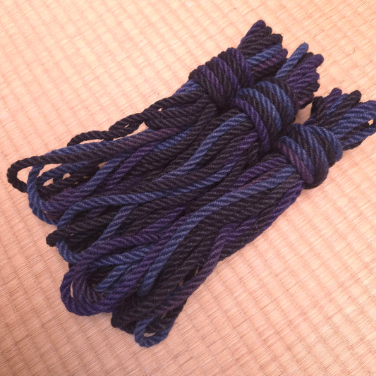 Blue Black rope bundled in a knot on a tatami Floor angled side view