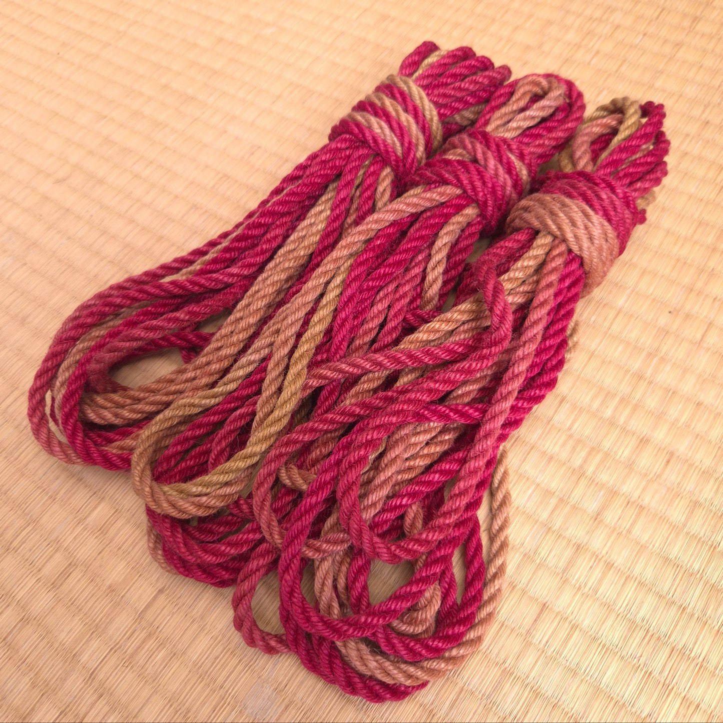 Coiled red and brown rope on a textured tatami surface